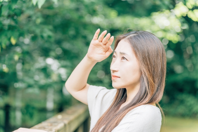 白内障の症状で日差しがまぶしく感じる女性